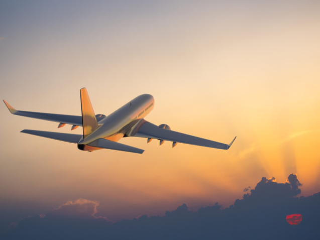 Passanger airplane flying above clouds in evening.